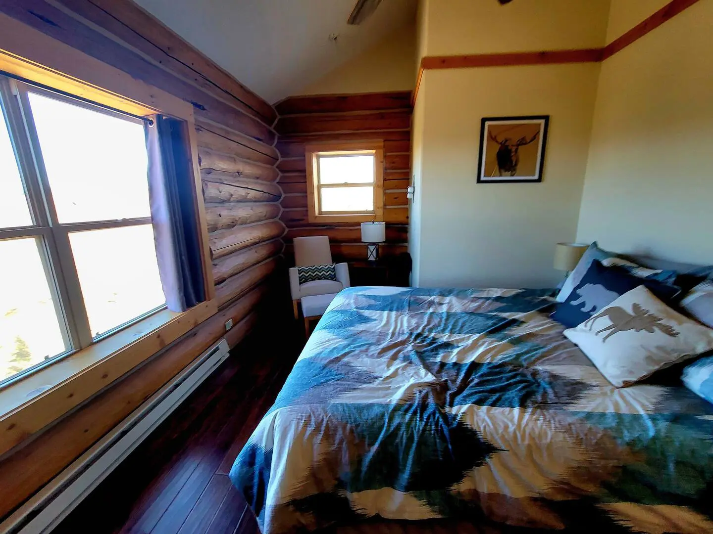 A bedroom in a log cabin with a bed and a window.