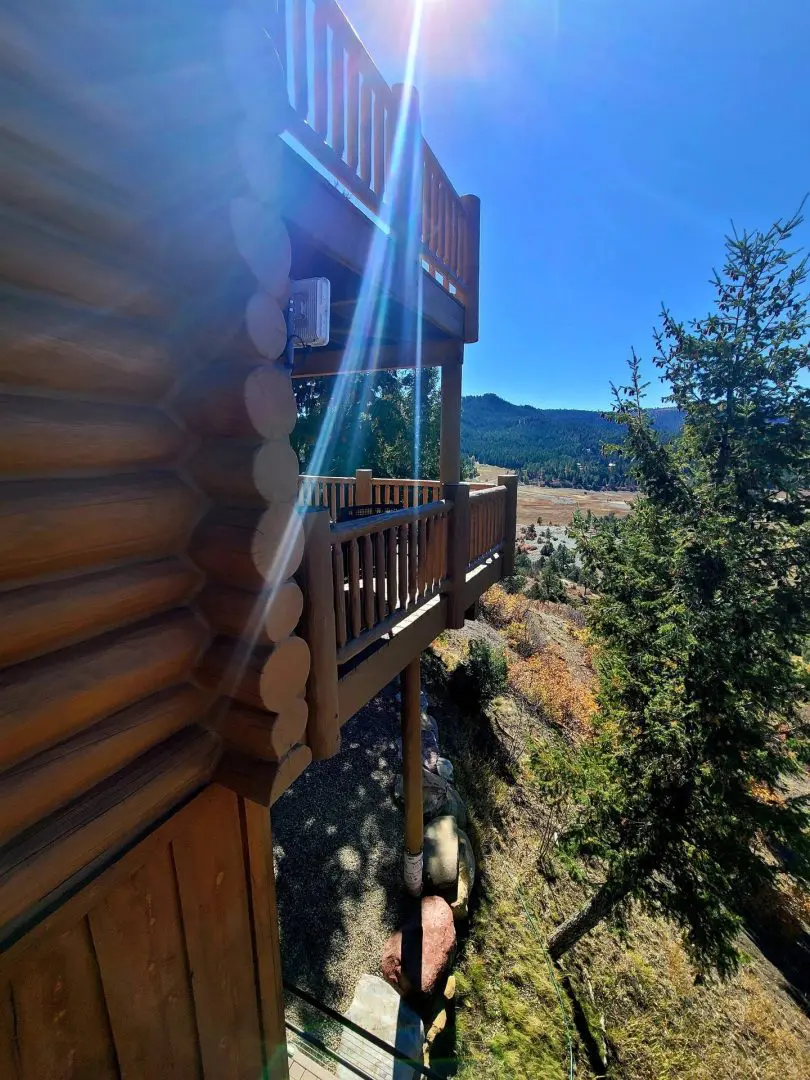 An aerial view of a log cabin with a view of the mountains.