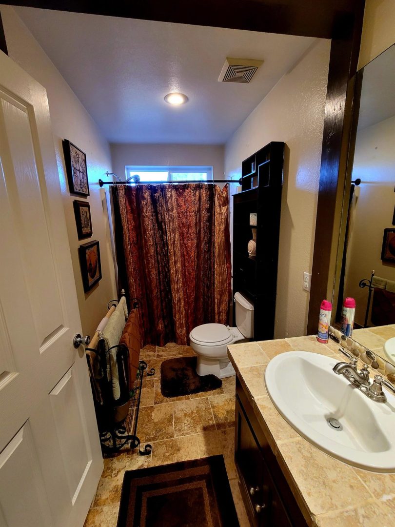 A bathroom with a toilet, sink and shower.