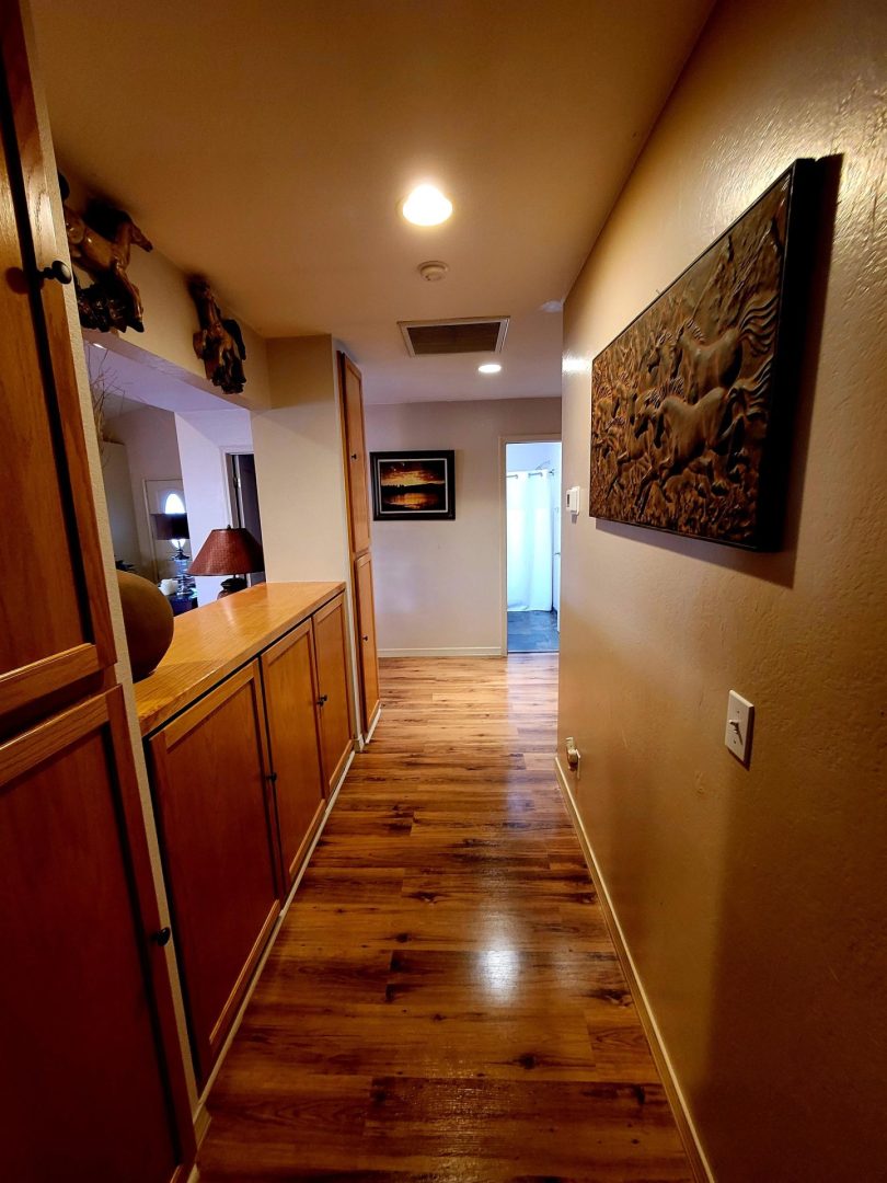 A hallway with wood floors and a painting.