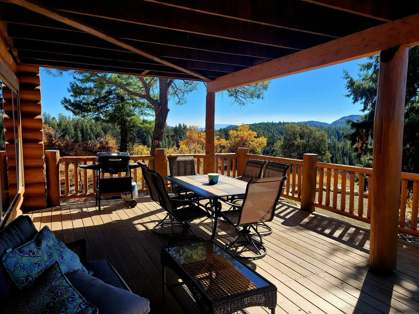 A deck with furniture and a view of the mountains.