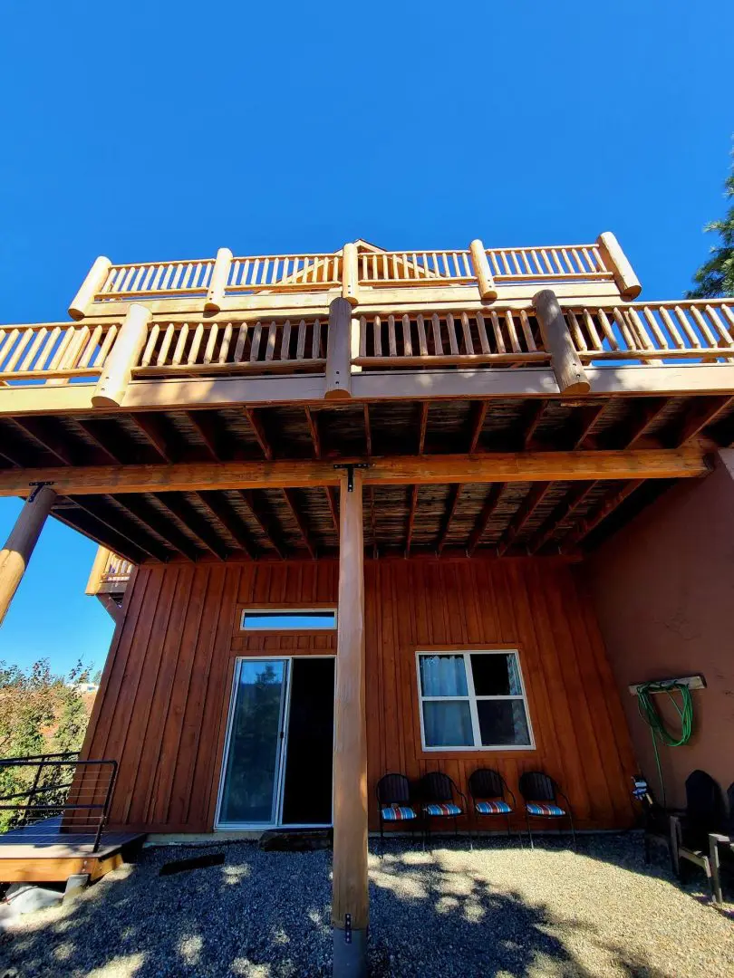 A house with a wooden deck and a balcony.