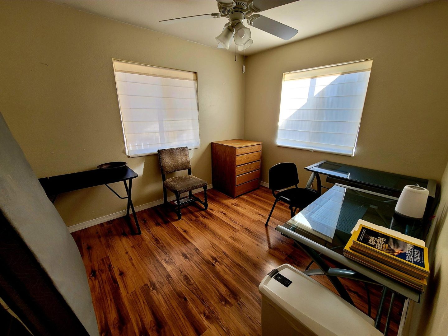 A small room with a desk and a fan.