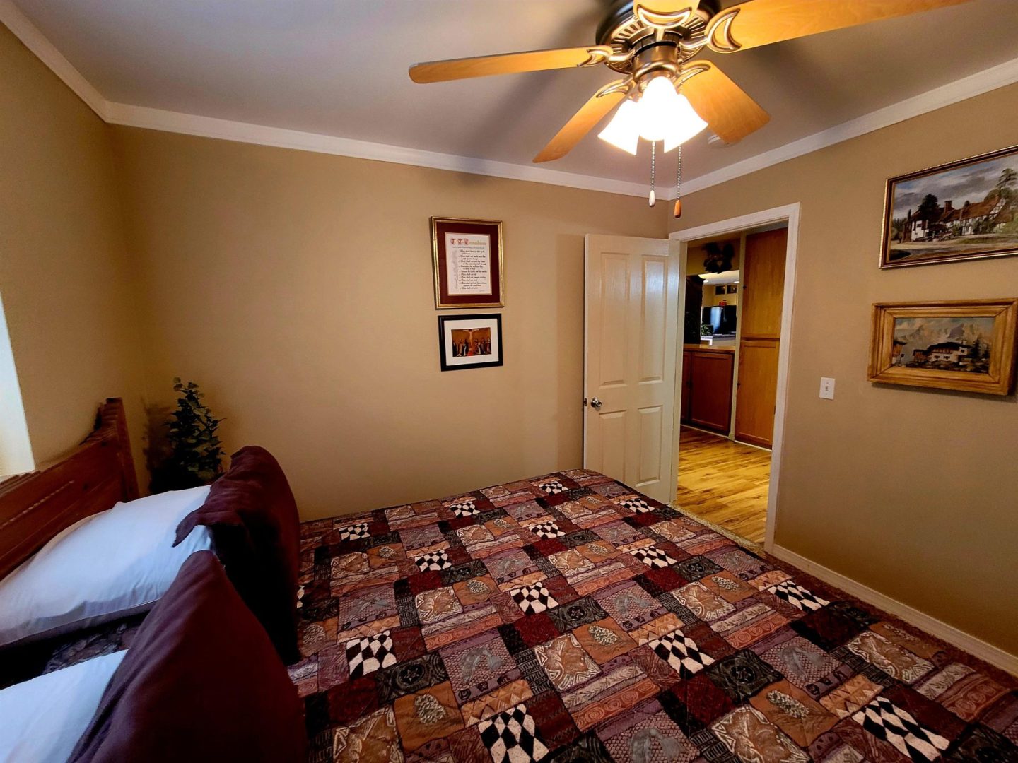 A bedroom with a bed and a ceiling fan.