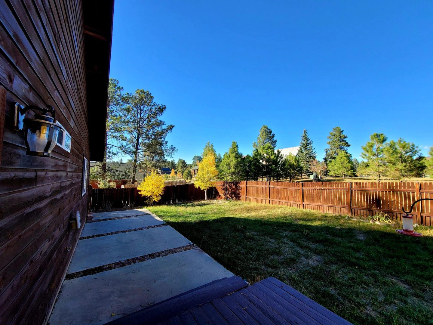 A backyard with a wooden fence and trees.