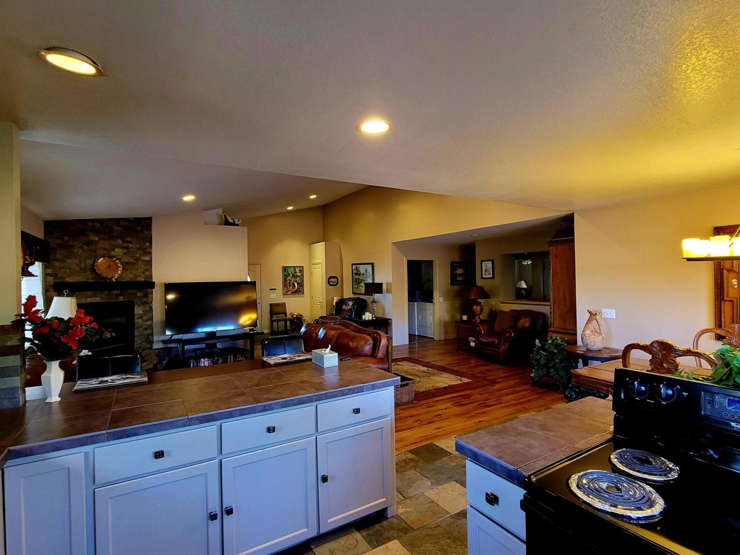 A kitchen with a stove and a living room.